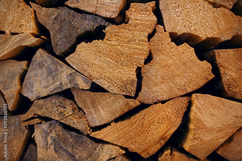 Fuel for stove heating. Rural life. Wooden firewood is stacked against the wall. Natural wood background. Free space for text Fuel for stove heating. Rural life. Wooden firewood is stacked against the wall. Natural wood background. Free space for text