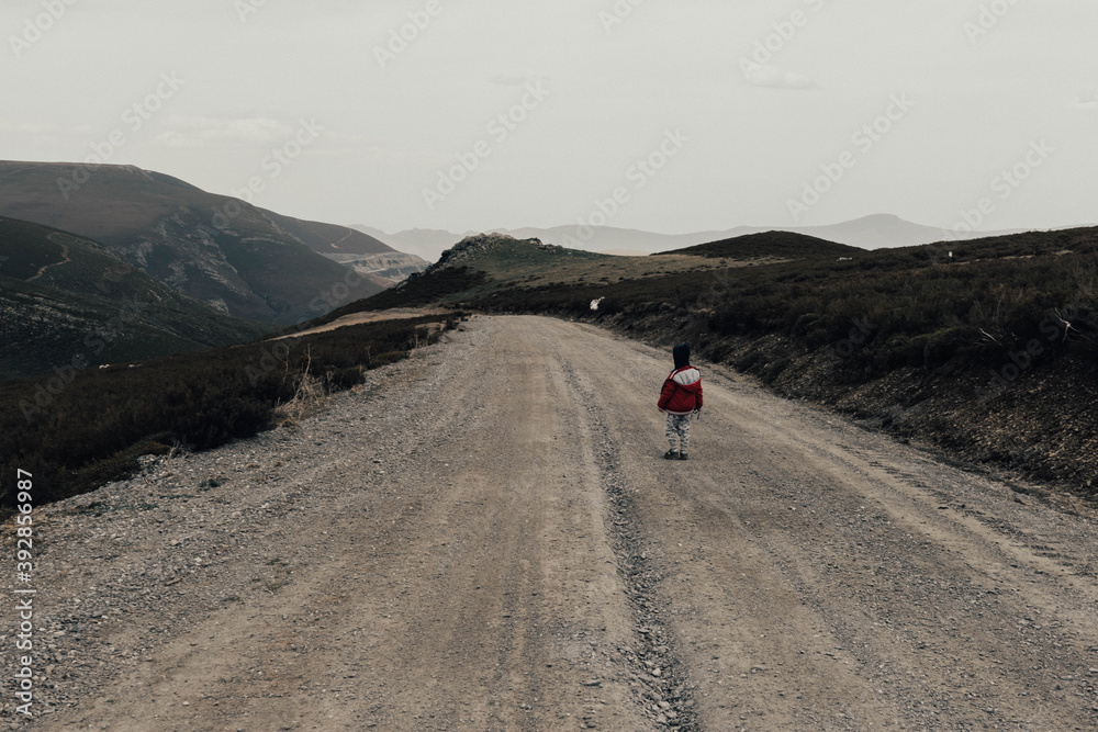 child 
 walking away on the road