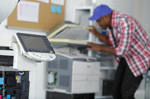 male technician repairing digital photocopier machine