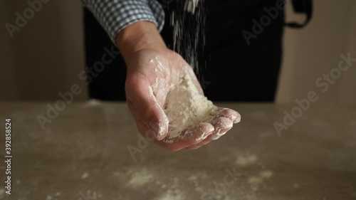 Baker pours flour from hand to hand