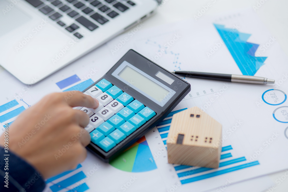 Hand of business man agent calculating loan of finance and investment for real estate, businessman and invest in property about home, construction or mortgage of home, male using calculator. Hand of business man agent calculating loan of finance and investment for real estate, businessman and invest in property about home, construction or mortgage of home, male using calculator.