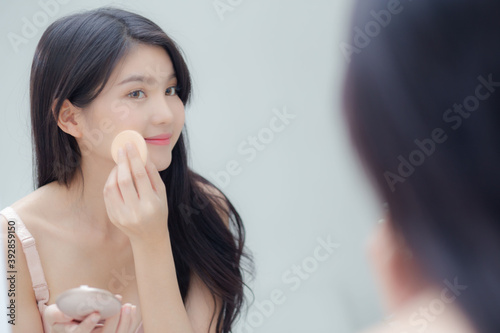 Closeup hand of young asian woman holding product cosmetic applying cream in jar, beautiful girl hand touch lotion for rejuvenation, beauty perfect, treatment and skin care and health concept.