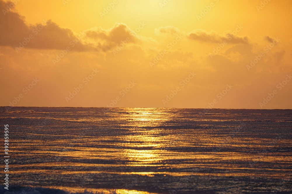 Beautiful golden beach sunrise on the Mediterranean coast with sun reflection. Clouds. Golden hour.