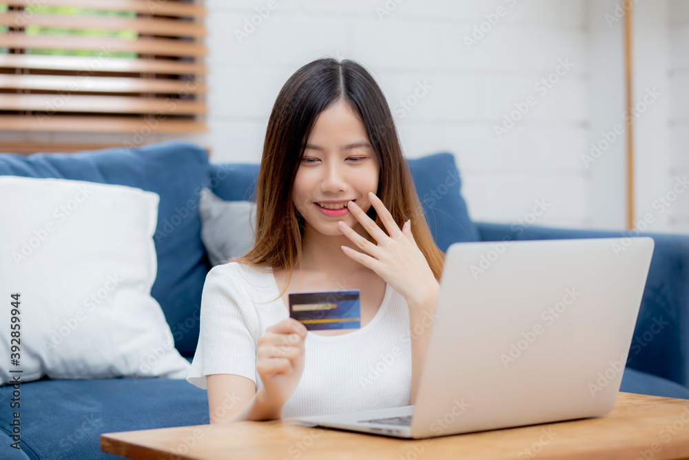 Young asian woman sit on sofa using laptop computer shopping online with credit card buy to internet and surprise, happy girl payment with e-business on couch, success and excited, business concept. Young asian woman sit on sofa using laptop computer shopping online with credit card buy to internet and surprise, happy girl payment with e-business on couch, success and excited, business concept.