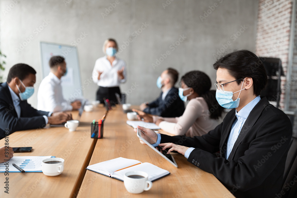 Asian Businessman In Mask Using Tablet During Corporate Meeting Indoor Asian Businessman In Mask Using Tablet During Corporate Meeting Indoor