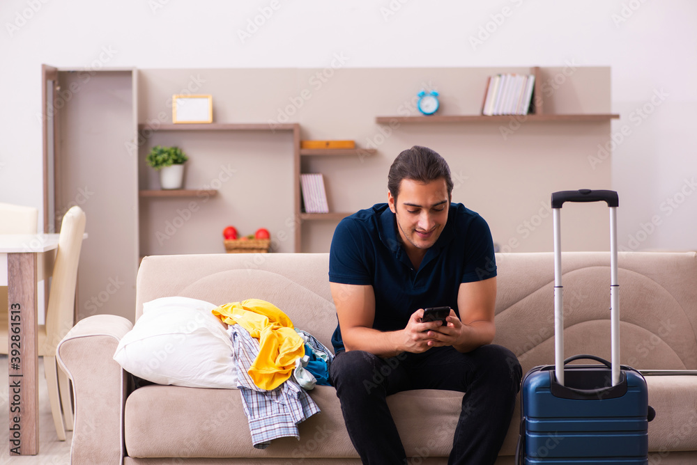 Young man preparing for journey at home Young man preparing for journey at home