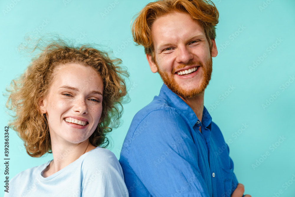 Young happy redhead couple smiling while posing back to back