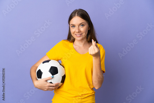 Young Lithuanian football player woman isolated on purple background making money gesture © luismolinero
