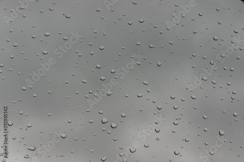 Water drops on window background on cloudy day.