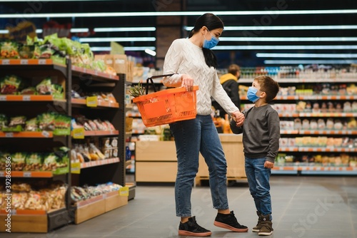 Mother and son are shopping at the grocery store. They wear masks during quarantine. Coronavirus Pandemic .COVED-19 Flash. The epidemic of the virus