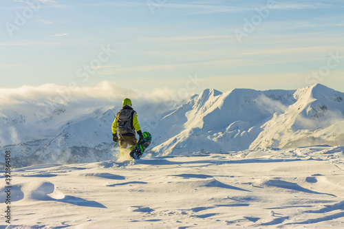 Tableau sur toile Snowboarder freerider is standing in the snowy mountains in winter under the clo
