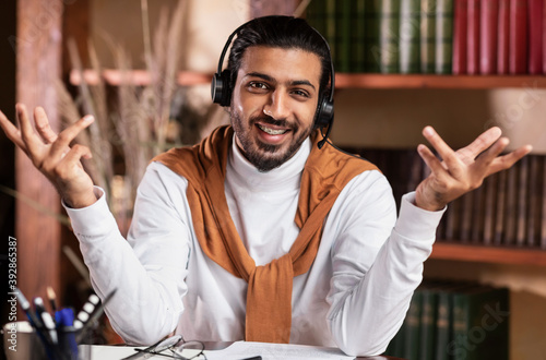 Smiling Arab Teacher Talking To Camera Teaching Online At Home