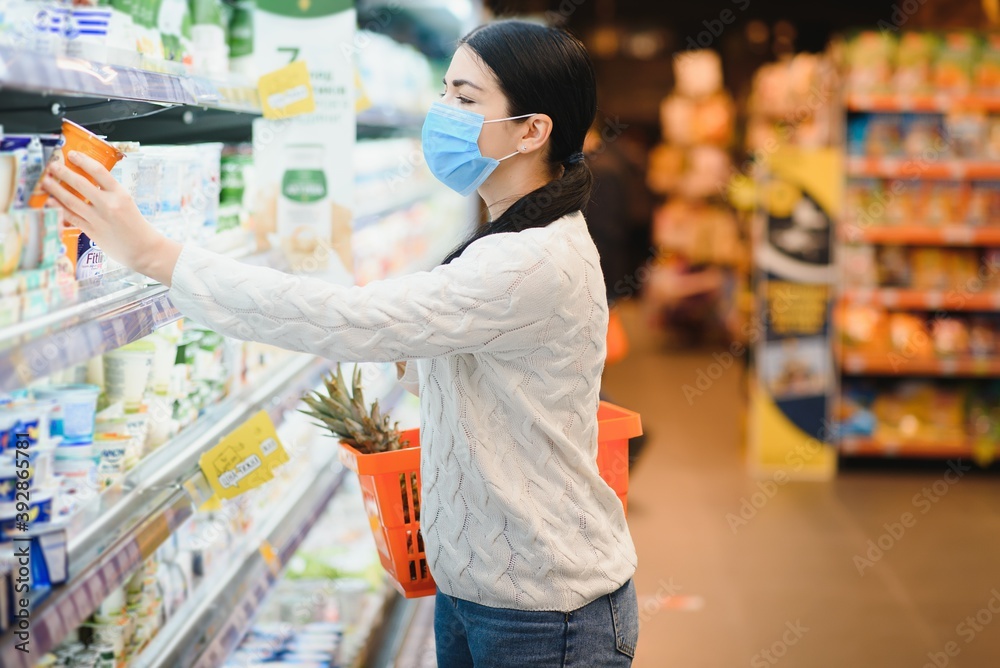 Woman wearing protective mask preparing for virus pandemic spread quarantine.Hygiene, cleaning and disinfection products.Preventive measures and protection.Supply shopping during the epidemic.