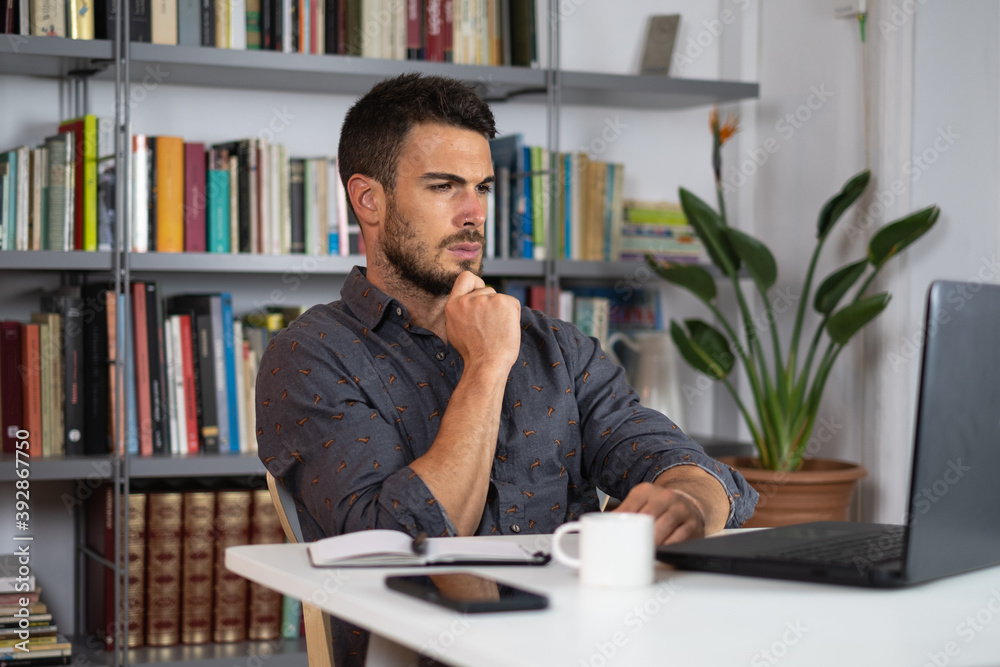 Handsome male working on laptop from home Handsome male working on laptop from home