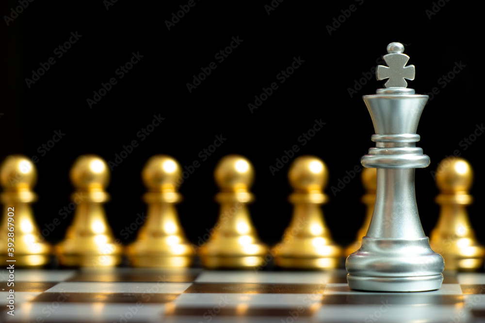 Silver king chess piece face with gold team on black background (Concept for company strategy, business decision and encounter the problem) Silver king chess piece face with gold team on black background (Concept for company strategy, business decision and encounter the problem)