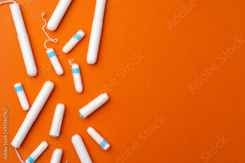 Medical female tampons on orange background top view