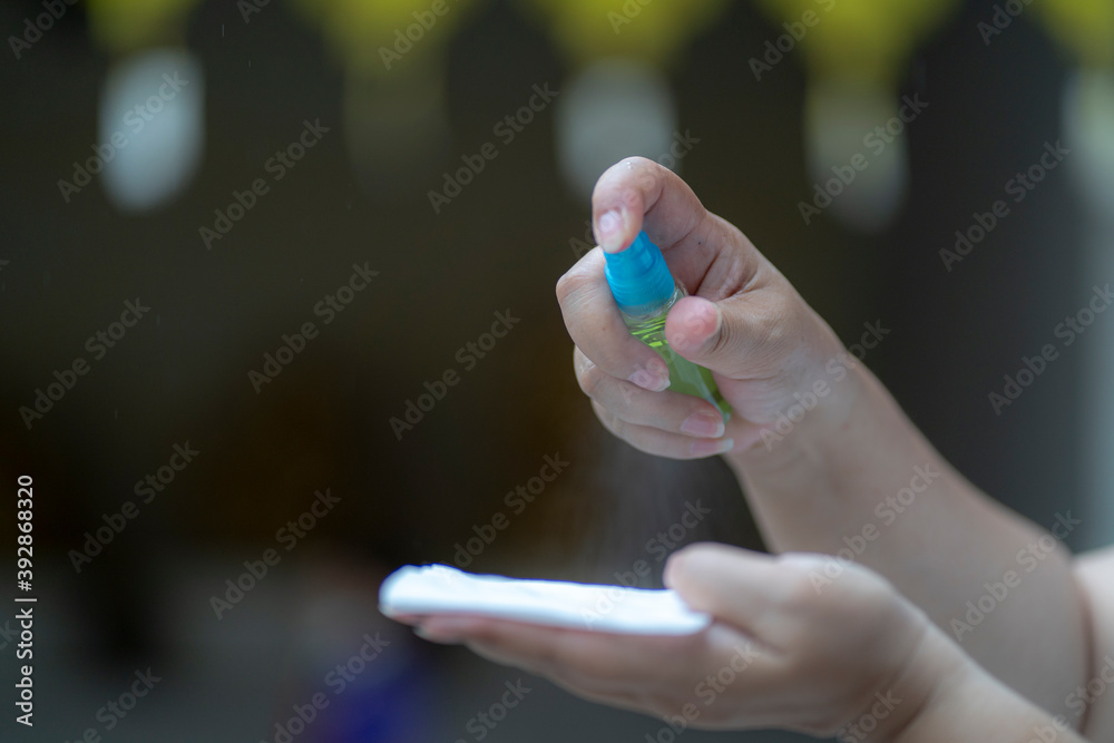 close up hand using sanitizer spray for killing bacteria and virus. close up hand using sanitizer spray for killing bacteria and virus.