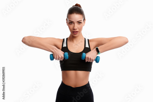 Young caucasian woman making weightlifting isolated on white background. Sport dumbbell woman inflated muscles