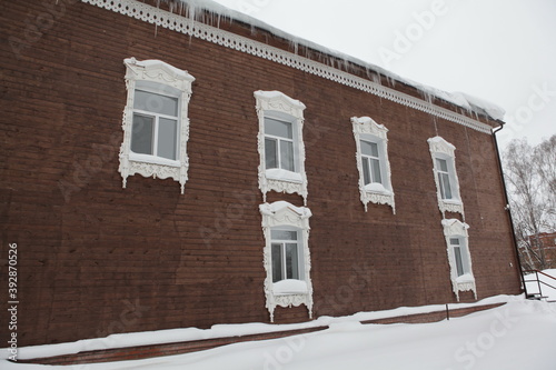 Vintage wooden house with ornamental carved windows, frames on Dzerzhinsky Street, 7a, Tomsk city, Russia. Russian style in architecture. Tomsk architectural landmark photo