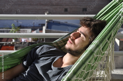 Chico joven durmiendo la siesta en una hamaca paraguaya photo