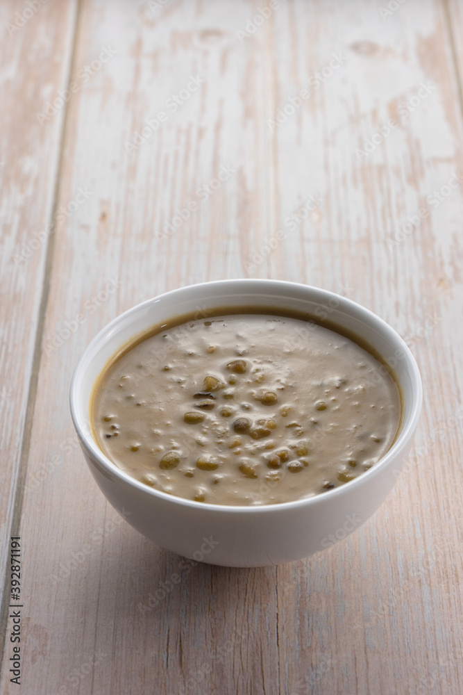 Mung beans porridge (bubur kacang hijau) is a Malaysian traditional dish usually eat as starter or desert. Made from mung beans, coconut milk & palm sugar. Isolated over wooden background. Mung beans porridge (bubur kacang hijau) is a Malaysian traditional dish usually eat as starter or desert. Made from mung beans, coconut milk & palm sugar. Isolated over wooden background.