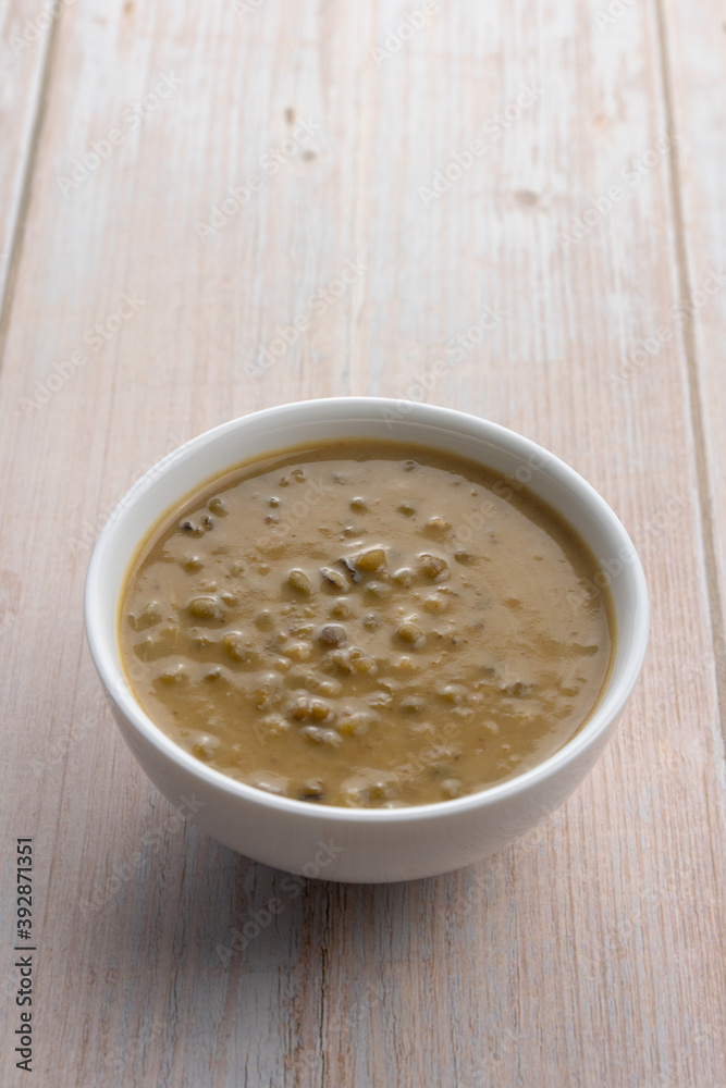 Mung beans porridge (bubur kacang hijau) is a Malaysian traditional dish usually eat as starter or desert. Made from mung beans, coconut milk & palm sugar. Isolated over wooden background. Mung beans porridge (bubur kacang hijau) is a Malaysian traditional dish usually eat as starter or desert. Made from mung beans, coconut milk & palm sugar. Isolated over wooden background.