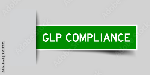 Inserted green color sticker label with word GLP (Good Laboratory Practice) compliance on gray background