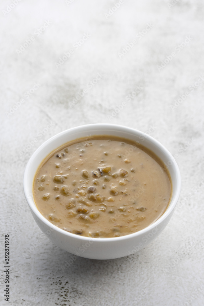 Mung beans porridge (bubur kacang hijau) is a Malaysian traditional dish usually eat as starter or desert. Made from mung beans, coconut milk & palm sugar. Isolated over wooden background. Mung beans porridge (bubur kacang hijau) is a Malaysian traditional dish usually eat as starter or desert. Made from mung beans, coconut milk & palm sugar. Isolated over wooden background.