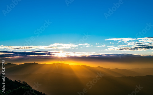 Landscape images of The morning sun, where a beautiful beam of light covers the mountain range, And the light reflected on the clouds in the sky, to nature background concept.