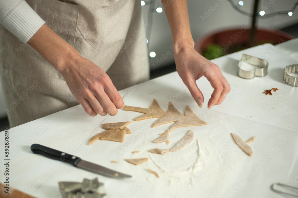 Woman in apron preparing Christmas ginger cookies.