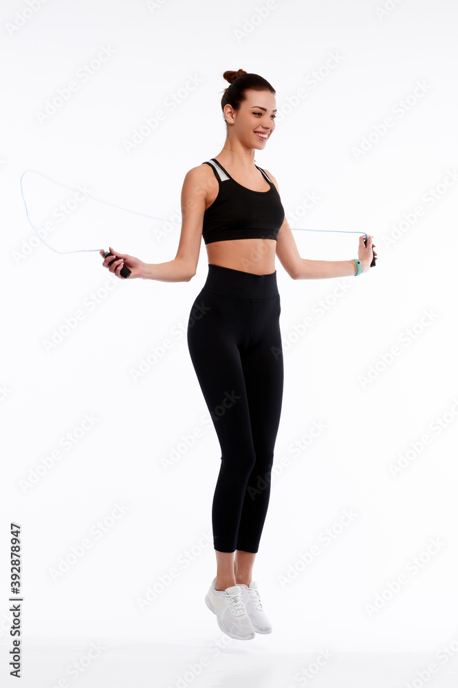 Spotrswoman jumping with rope on white isolate background. Fitness female doing physical exercise. Healthcare and weightlose concept Spotrswoman jumping with rope on white isolate background. Fitness female doing physical exercise. Healthcare and weightlose concept