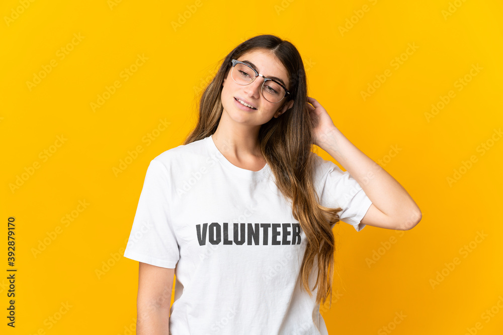 Young volunteer woman isolated on yellow background having doubts Young volunteer woman isolated on yellow background having doubts