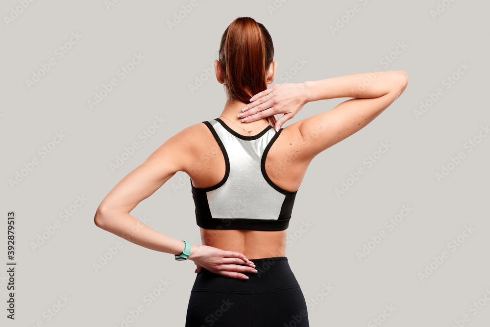 Female body showing pain in back spine. Sportswoman feeling acute pain in neck on white background.Medical concept Female body showing pain in back spine. Sportswoman feeling acute pain in neck on white background.Medical concept