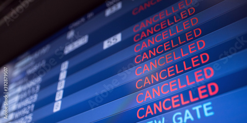 Flight information board displaying cancelled flights in international airport during COVID-19 pandemic  photo