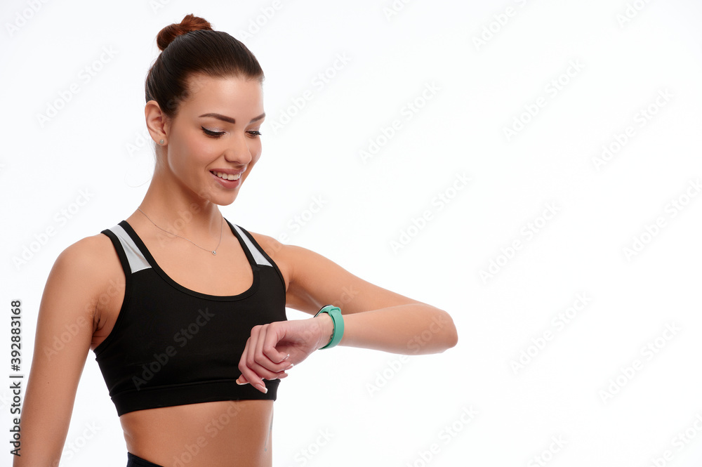 Slim strong caucasian woman in sportswear check smart watches on white isolated background Slim strong caucasian woman in sportswear check smart watches on white isolated background
