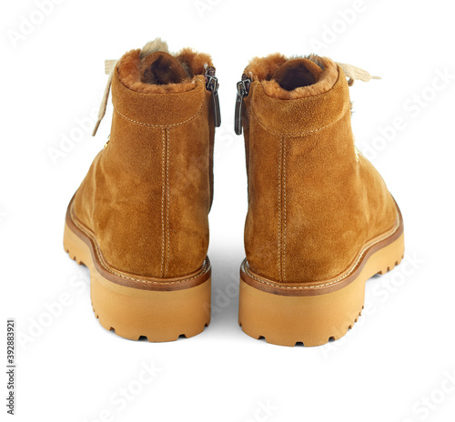 Beautiful pair of winter fur-insulated shoes made of yellow-beige suede on lace, with a sole with a rough protector, isolated on a white background with a shadow. Rear view. 
