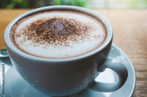 closeup coffee cup on wood table bar in restaurant or cafe with copy space. fresh beverage.