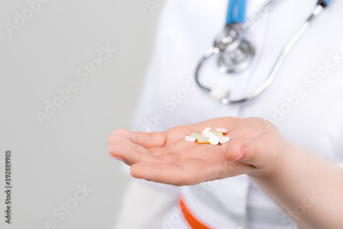 Photo of doctor with drugs in hands on light background