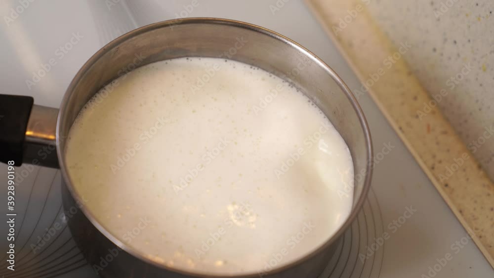 milk boils in a saucepan on the stove and pours on the stove. inattention in the kitchen. milk boils in a saucepan on the stove and pours on the stove. inattention in the kitchen.