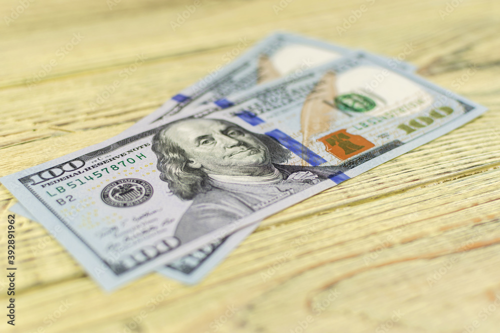 Hundred dollar bills on a wooden background. Hundred dollar bills on a wooden background.