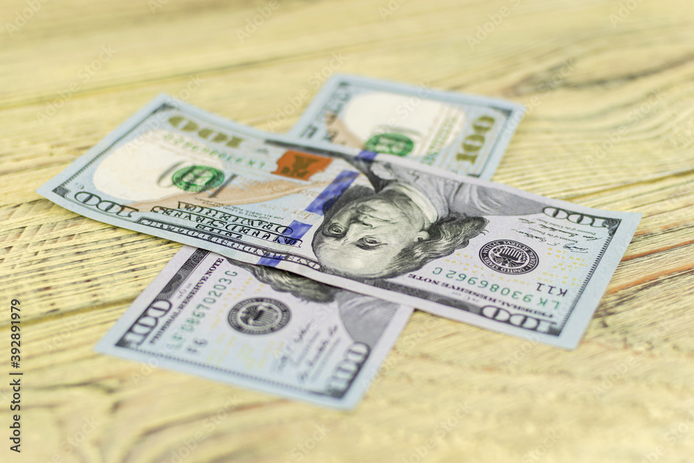Hundred dollar bills on a wooden background. Hundred dollar bills on a wooden background.