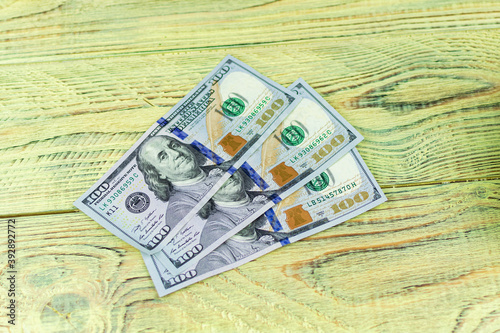 Hundred dollar bills on a wooden background.