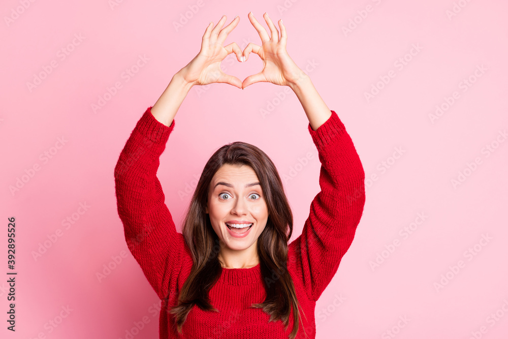 Photo of young charming girl raise hands open mouth show heart shape wear red sweater isolated pink color background Photo of young charming girl raise hands open mouth show heart shape wear red sweater isolated pink color background