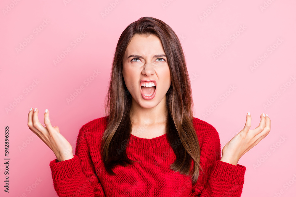 Portrait photo of aggressive outraged young girl wearing red outfit gesturing with both hands grinning opened mouth looking up annoyed isolated on pink color background