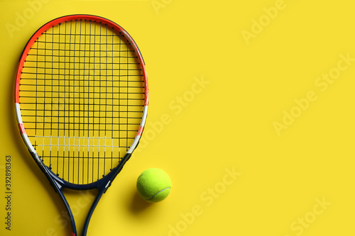 Tennis racket and ball on yellow background, flat lay. Space for text