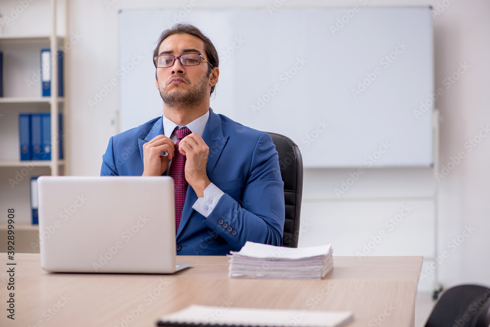 Young male employee sitting in the office in front of whiteboard