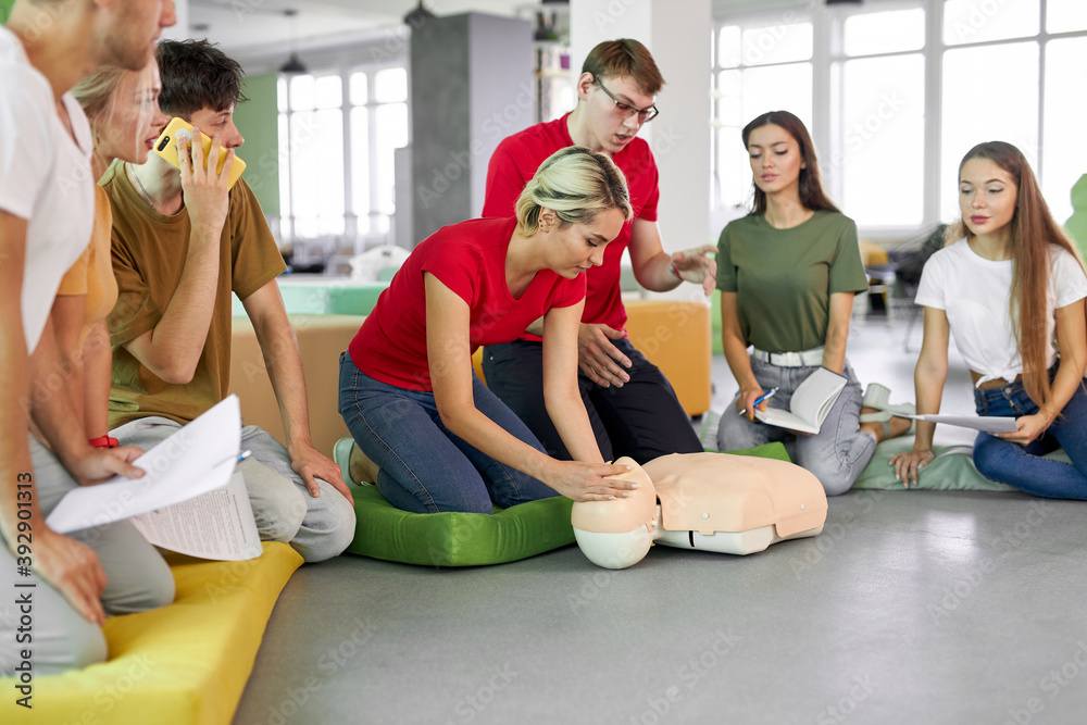 young woman ask question how to save life by instructor, practice on dummy young woman ask question how to save life by instructor, practice on dummy