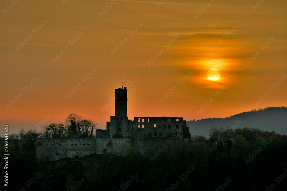 Die Burg Königstein im Taunus mit einem Sonnenuntergang hinter einer Nebelschicht