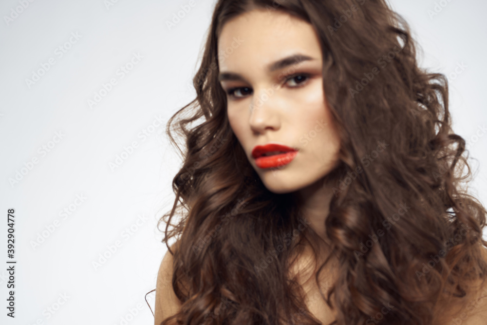 woman with bare shoulders wavy hairstyle glamor makeup light background