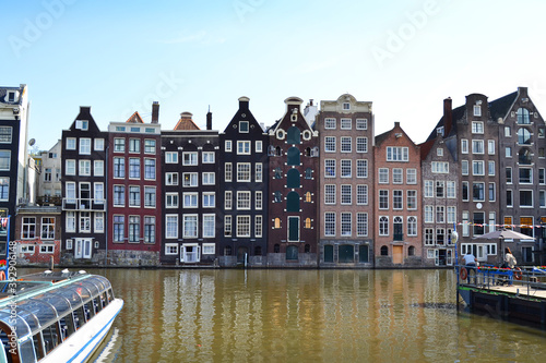 Famous vintage buildings on the canal in Amsterdam. General landscape view at tradition Dutch architecture, The Netherlands.